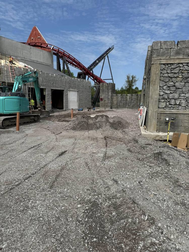 The same site before surfacing, showing broken ground, an excavator and stockpiled material.
