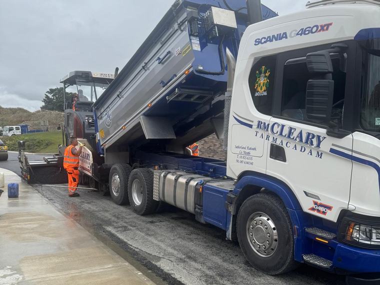 An RM Cleary Scania G460 tipper discharging asphalt into the paver.