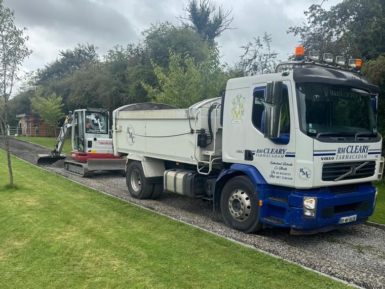 The RM Cleary Volvo FE 280 rigid tipper loaded on a gravel drive, with one of the tracked excavators behind it.