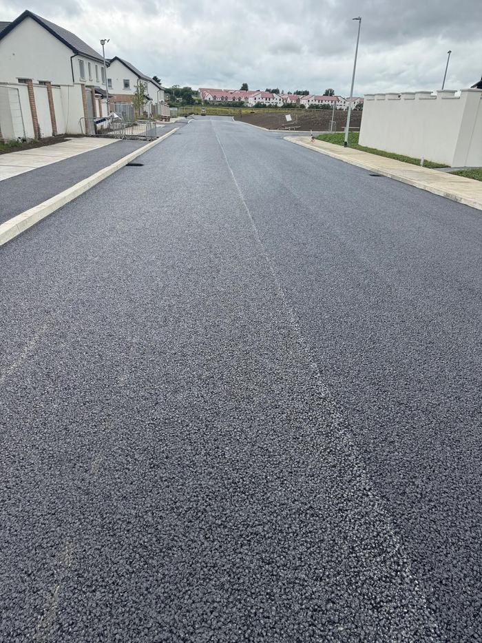 The finished estate road looking down between the houses, kerbed both sides.