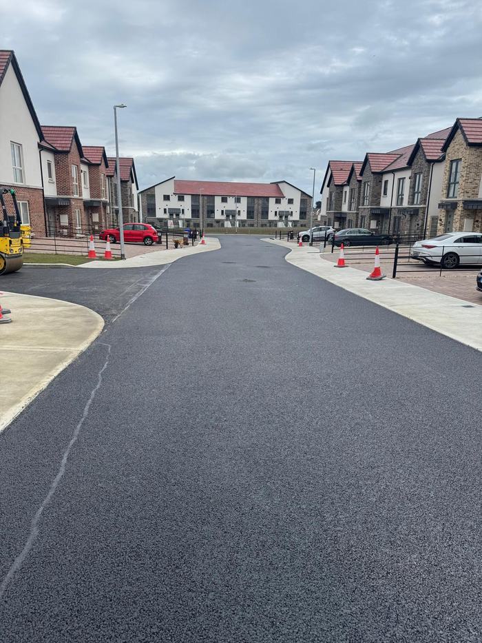 The completed road at the junction, kerbed and edged against the new footpaths.