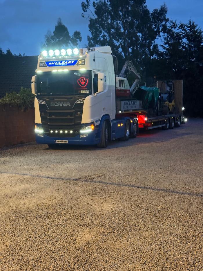 The RM Cleary low-loader at dusk with the paver, roller and excavator loaded and ready to travel.