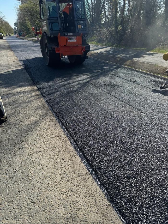 The roller compacting up to the joint between the completed run and the fresh material.